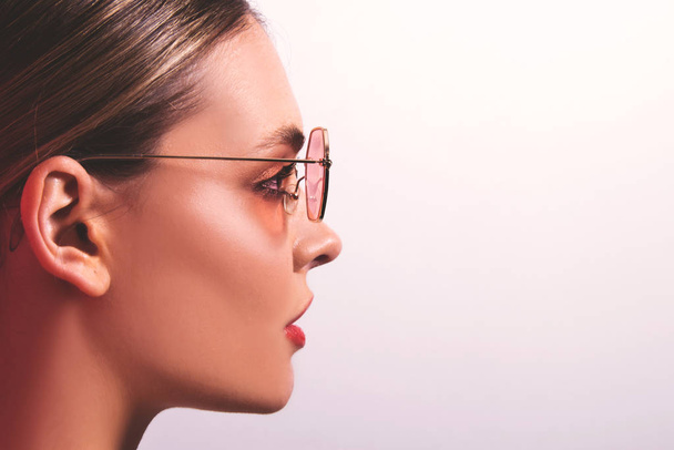 Portret pięknej modelki w okularach z bliska. Młoda kobieta, brunetka w okularach przeciwsłonecznych, odizolowany, gotowy plakat reklamowy, studio  - Zdjęcie, obraz