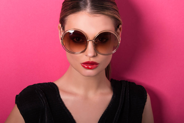 Retrato de belo modelo com óculos de perto. Mulher jovem, menina morena com óculos de sol, isolado, cartaz comercial pronto, estúdio
  - Foto, Imagem