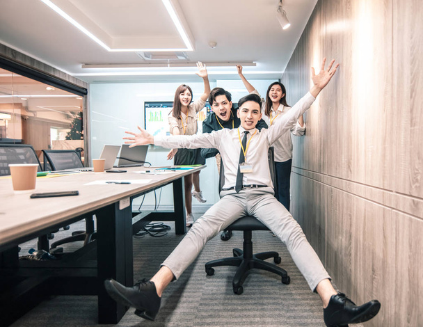 business people having fun riding on chairs in office - Photo, Image