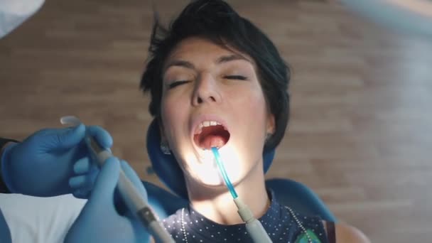 the girl at the dentist at the reception makes a filling in the tooth - Кадри, відео