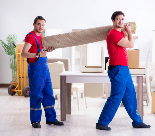 Zwei Mitarbeiter eines Bauunternehmens transportieren persönliche Gegenstände - Foto, Bild