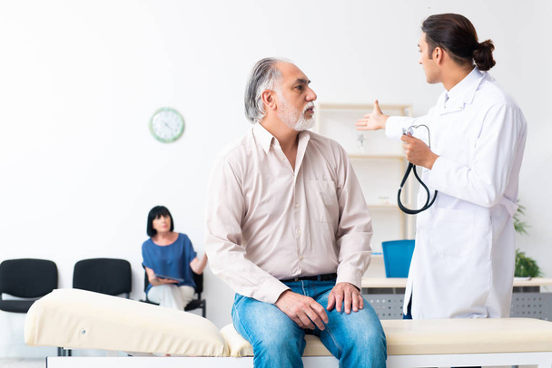 Old couple visiting young male doctor - Photo, Image