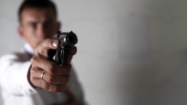 Мужчина поднимает руку с пистолетом на белом фоне
 - Кадры, видео