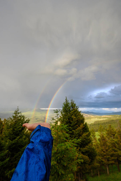 das Ende eines Regenbogens hochhalten - Foto, Bild