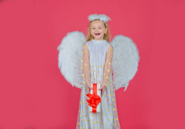 Valentines Day. Angel child from heaven gives you gift. Portrait of beautiful angel little girl with angels wings. Angel child. Cherub. Beautiful child angel posing and looking at camera. - Fotoğraf, Görsel