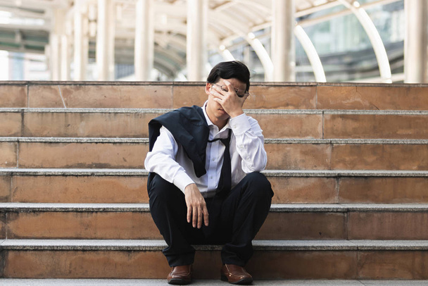 Desempleado estresado joven hombre de negocios asiático que sufre de depresión severa. Concepto de fracaso y despido. - Foto, imagen