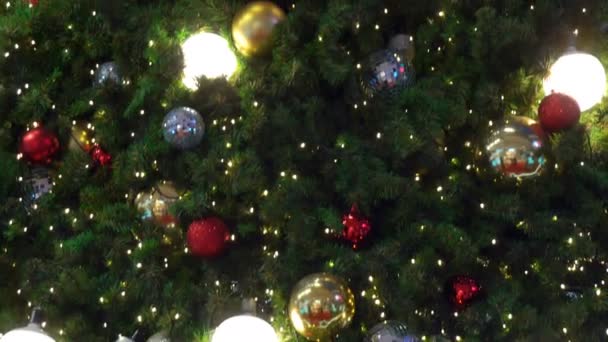 Işıklarla ve hediyelerle süslenmiş Noel ağacı ve altın, gümüş, renkli toplar yükseliyor - Video, Çekim