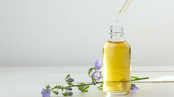 aceite esencial de campanilla en hermosa botella sobre fondo blanco
 - Imágenes, Vídeo