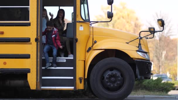 Motorista de ônibus escolar do sexo feminino dizendo adeus aos alunos
 - Filmagem, Vídeo