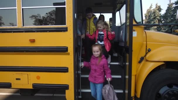 Kisdiákok szállnak le a buszról és mennek iskolába. - Felvétel, videó