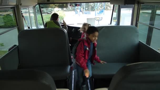 Vrolijke schoolkinderen die plaatsnemen in de bus - Video