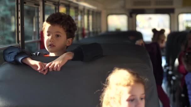 Portrét kudrnatého školáka na koni školní autobus domů - Záběry, video