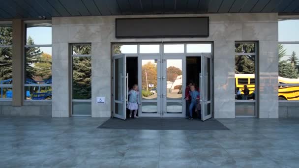 Szczęśliwe dzieci szkolne wybiegające z drzwi szkoły - Materiał filmowy, wideo