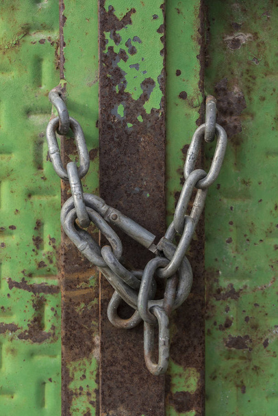 Serratura chiusa con catena su una vecchia porta metallica
 - Foto, immagini