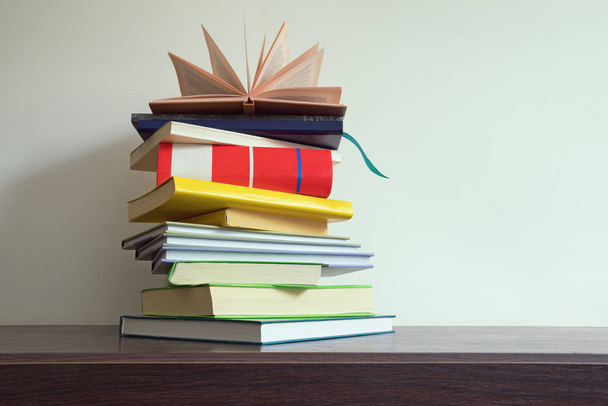 Stapel Bücher in verschiedenen Größen und Farben auf dem Tisch, freier Platz für Text  - Foto, Bild
