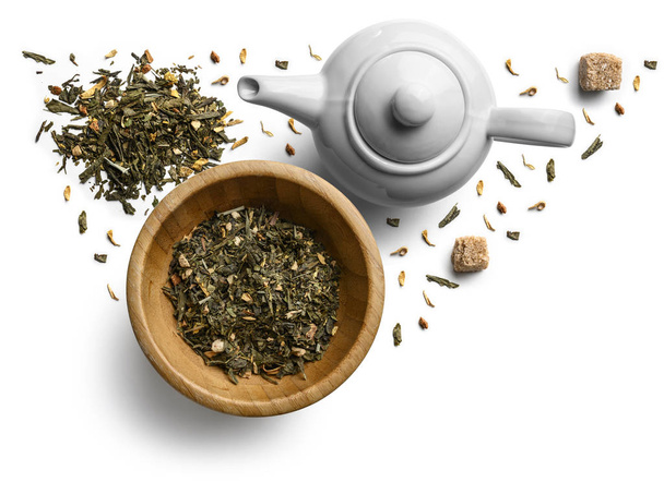 Grüner Tee mit natürlichen aromatischen Zusätzen und einer Teekanne. Draufsicht auf weißem Hintergrund - Foto, Bild