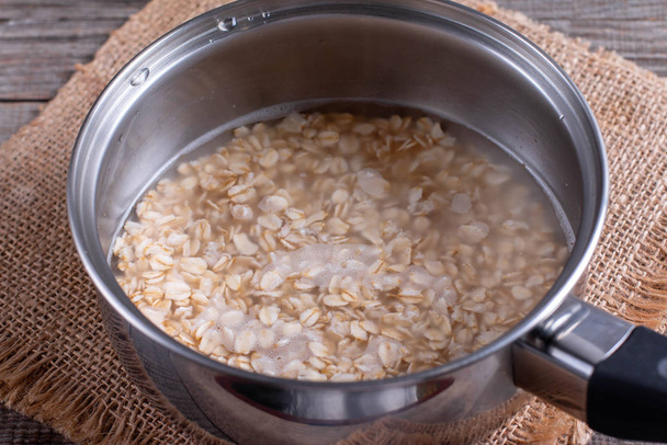 Oatmeal porridge in a saucepan - Fotoğraf, Görsel