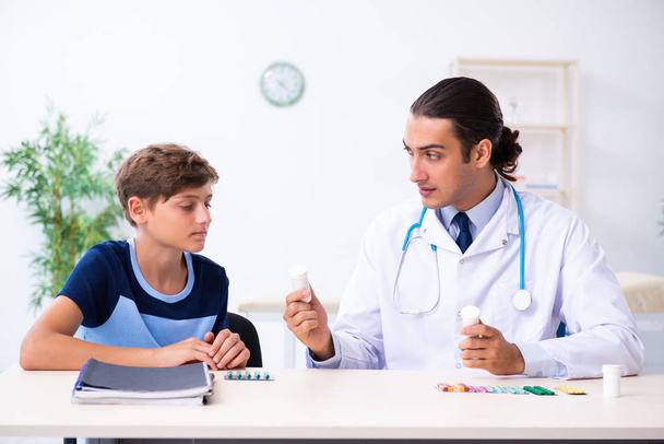 Jovem médico examinando menino na clínica
 - Foto, Imagem