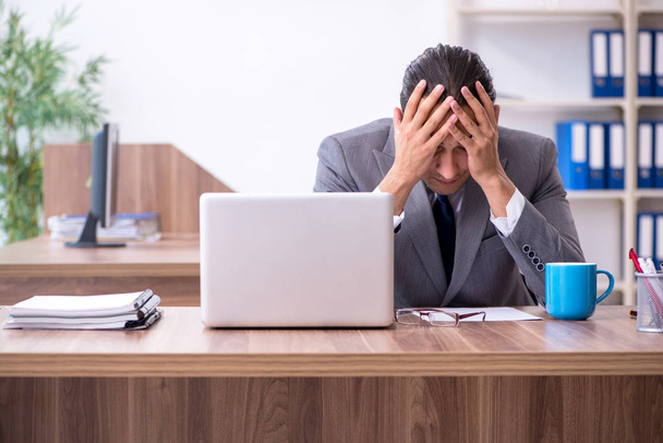 Unhappy male businessman in the office - Foto, afbeelding