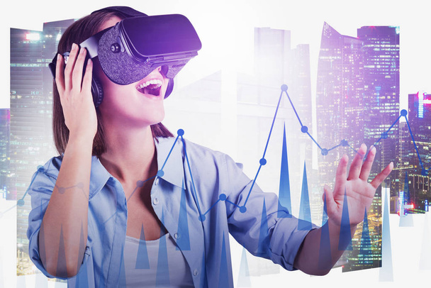 Happy woman in VR glasses using digital graph - 写真・画像