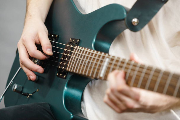 Close up of man playing on electric guitar - Fotó, kép