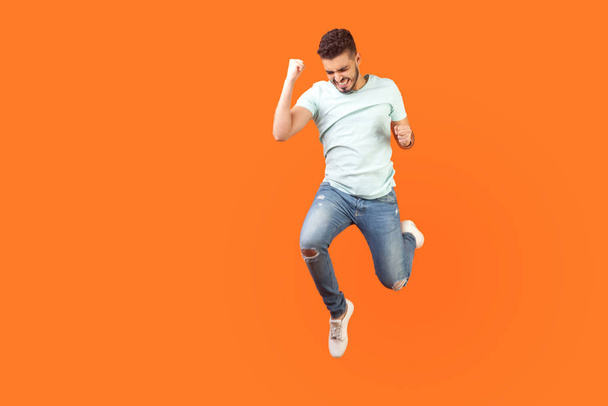 Full length portrait of ecstatic brunette man jumping in air sho - Photo, image