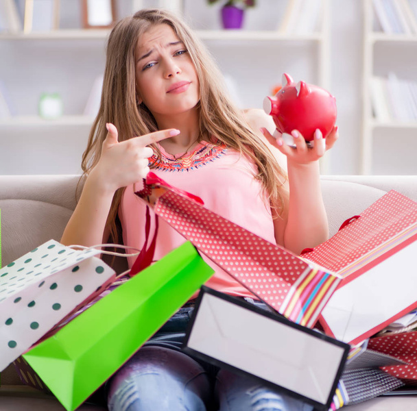 Giovane donna con borse della spesa in casa sul divano - Foto, immagini