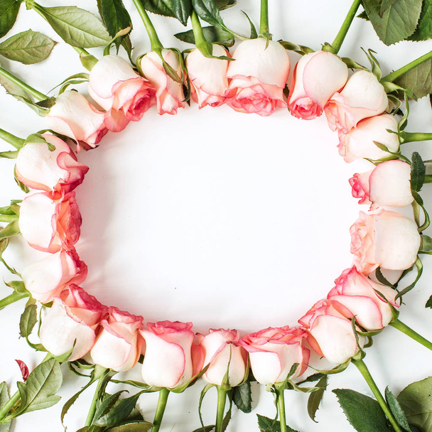 Rahmen mit leeren Kopierraum-Attrappen aus rosafarbenen Rosenblüten auf weißem Hintergrund. flache Lage, von oben betrachtet florales Konzept. - Foto, Bild