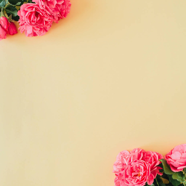 Rózsaszín rózsa virágok üres másolás tér keret határ sárga alapon. Lapos fektetés, felülnézet minimális virágos mockup. - Fotó, kép