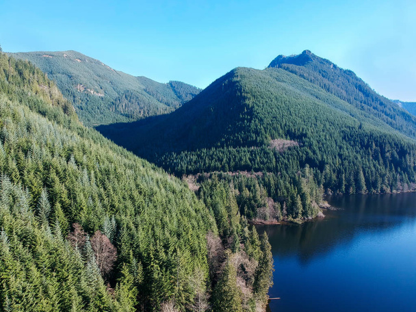 Rarely seen beautiful aerial photographs of Calligan Lake in Washington State with green mountainside open vistas clouds blue sky and shoreline on a warm autumn day. - Photo, Image