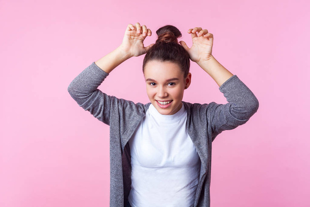 Portrait of adorable funny brunette teen girl showing bunny ears - Foto, Imagem
