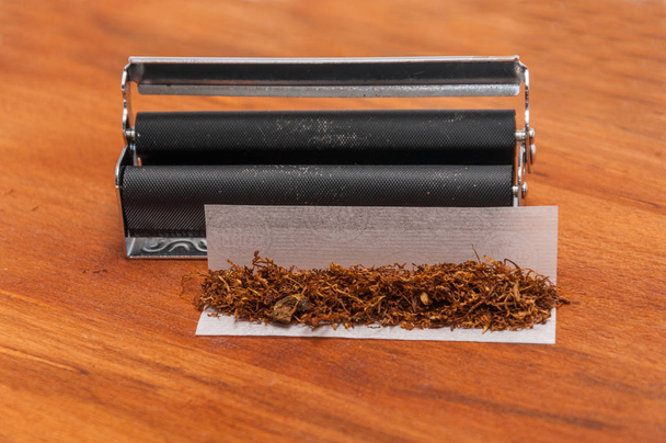 Hnědé ruční válcování tabáku na dřevo na papíře a válcování mach - Fotografie, Obrázek
