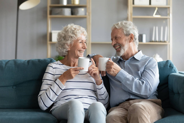 Pretty 70s hoary spouses holding coffee cups laughing enjoy talk - Zdjęcie, obraz