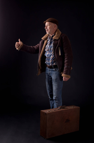 Old man with suitcase hitchhiking - Фото, зображення