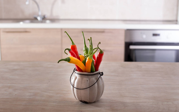 Chili peppers in bowl in kitchen - Zdjęcie, obraz