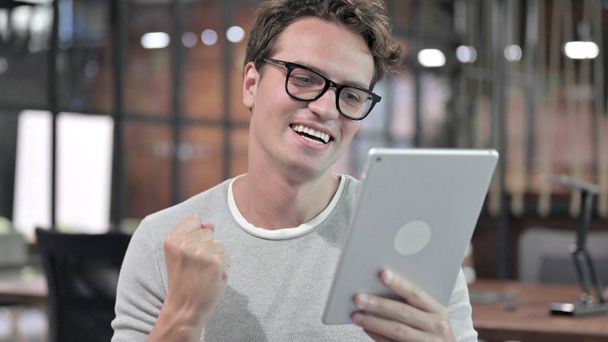 Retrato de un chico exitoso celebrando mientras usa Tablet
 - Foto, Imagen