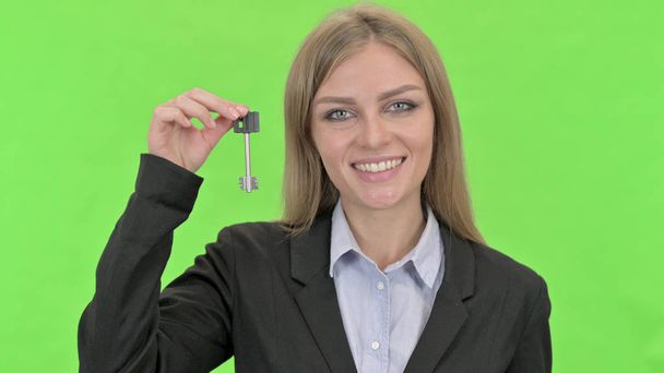 Ελκυστική επιχειρηματίας δείχνοντας κλειδί για το κλειδί αποχρώσεων - Φωτογραφία, εικόνα