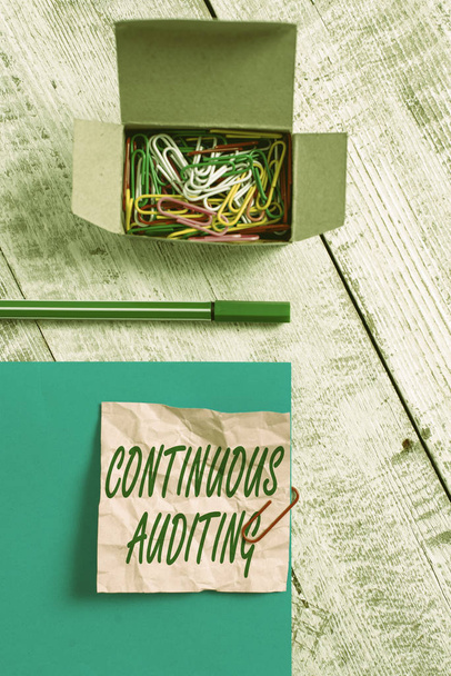 Conceptual hand writing showing Continuous Auditing. Concept meaning Internal process that examines accounting practices Wrinkle paper and cardboard placed above wooden background - Photo, Image