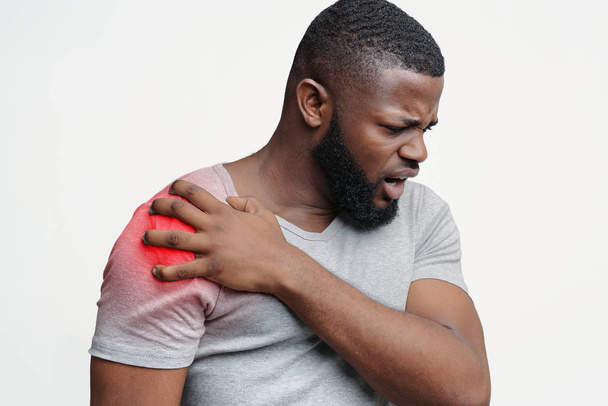 Молодий чоловік страждає від болю в плечі
 - Фото, зображення