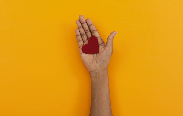 Červené cítil srdce v otevřené dlani černé ženy - Fotografie, Obrázek