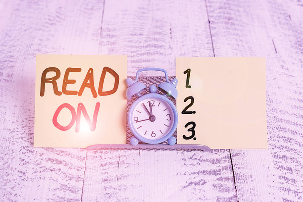 A felirat az Read On-t mutatja. Üzleti fotó szöveg időt tölteni olvasás annak érdekében, hogy megtudja információkat valamit Mini kék ébresztőóra felett áll puffer huzal között két jelölőlap - Fotó, kép