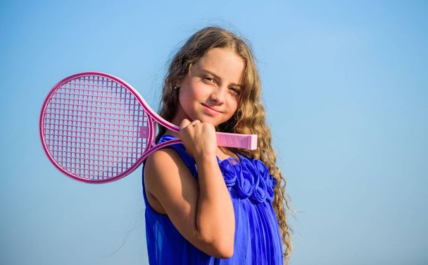 Active life. Child play tennis blue sky background. Sporty kid. Small girl with pink tennis racket. Summer leisure. Sport game. Playful cheerful kid. Happy childhood. Positive. Emotional baby - Photo, image