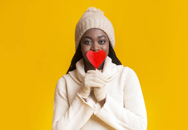 Μυστηριώδης afro κορίτσι χειμώνα καλύπτει τα χείλη της με κάρτα Αγίου Βαλεντίνου - Φωτογραφία, εικόνα