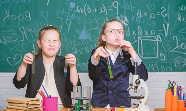 Girls study chemistry. Make studying chemistry interesting. Microscope and test tubes on table. Educational experiment concept. Be careful performing chemical reaction. Basic knowledge of chemistry - Photo, image