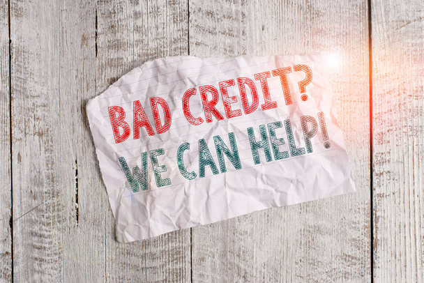 Textzeichen, die schlechte Kreditwürdigkeit Frage können wir helfen. Business-Foto zeigt Kreditnehmer mit hohen Risiken Schulden finanziellen zerknitterten zerrissenen Papier halb gebrochen platziert über klassischen Holzhintergrund - Foto, Bild