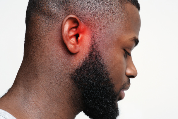 Ragazzo nero con orecchio infiammato, vista laterale
 - Foto, immagini