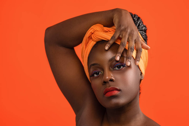Young African model with a beautiful makeup in studio in vivid background - Foto, afbeelding