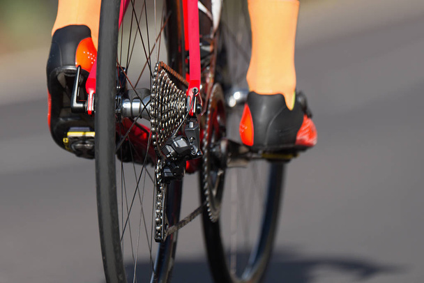 Dettaglio bici da corsa su ruote dentate e piedi
 - Foto, immagini