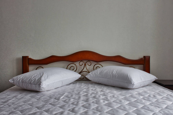белые простыни и подушки на кровати из красного дерева
 - Фото, изображение