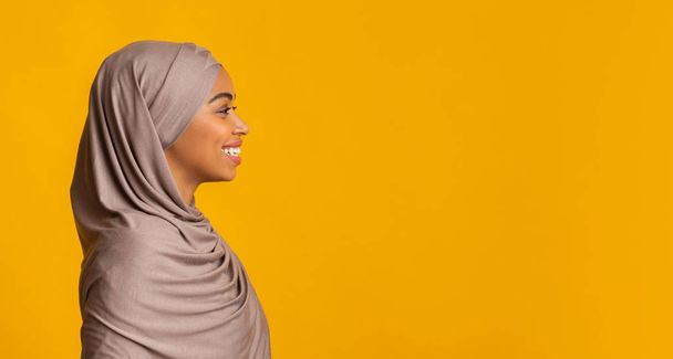 Profile portrait of smiling black muslim girl in hijab - Fotó, kép